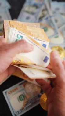 Avro banknotlarını sayan erkek eller. Arka planda Amerikan doları banknotları var. Yatırım, başarı, finansal beklentiler veya kariyer ilerlemesi kavramı.