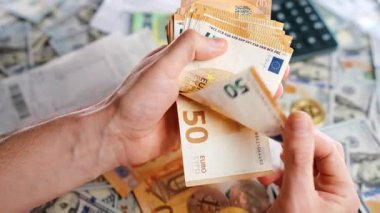 Ev muhasebe konsepti. Adam para hesaplıyor, aylık ev giderleri, vergiler ve kredi kartı faturaları. Yavaş çekim