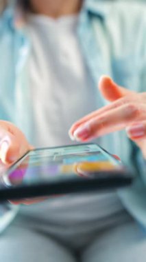 Sosyal medyada akıllı telefondan yayın yapan, dokunmatik ekranlara dokunan, kurye uygulaması kullanan bir kadın. Elinde cep telefonu olan bir kadın. Dikey video