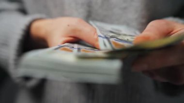 Amerikan Doları 'nı sayan bir kadın, yakın plan. Yatırım, başarı, finansal beklentiler veya kariyer ilerlemesi kavramı. 