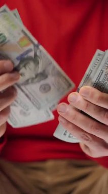 ABD Doları banknotlarını sayan adam, yakın plan. Yatırım, başarı, finansal beklentiler veya kariyer gelişimi kavramı. Dikey video