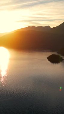 Vancouver 'ın kuzeyindeki güzel günbatımında deniz manzarası. Dağların siluetlerinin üzerine güneş batıyor. British Columbia, Kanada.