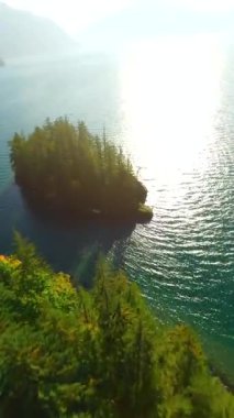 Kanada 'da göz kamaştırıcı sonbahar manzarası. Dağ yamaçlarındaki renkli ormanın havadan görünüşü ve Harrison Gölü, British Columbia. FPV insansız hava aracı tarafından çekildi.