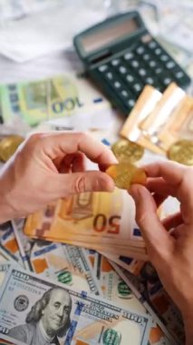 Erkek eli, BTC bitcoin 'i farklı para birimlerinin banknotları olan dolar ve avrolar ile karşılaştırır ve döndürür. Kripto para birimi kavramı ve engelleme teknolojisinin geniş dünyası..
