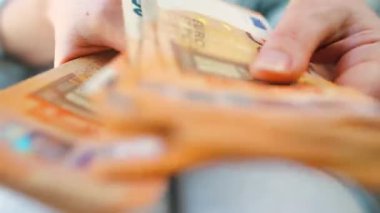 Avro banknotlarını sayan bir kadın, yakın plan. Yatırım, başarı, finansal beklentiler veya kariyer ilerlemesi kavramı.