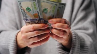 Amerikan Doları 'nı sayan bir kadın, yakın plan. Yatırım, başarı, finansal beklentiler veya kariyer ilerlemesi kavramı.