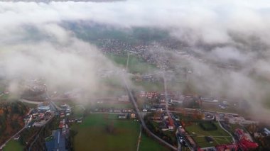 İtalya 'nın Dolomite Dağları' ndaki köy, Dolomite Dağları 'ndaki tarlaların, ormanların ve yolların bir kısmını gözler önüne sermek için beyaz, kabarık bulutların arasından nefes kesici bir görüntü geliyor..