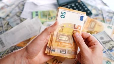 Ev muhasebesi konsepti. Adam para hesaplıyor, aylık konut giderleri, vergiler ve kredi kartı faturaları. Yavaş çekim