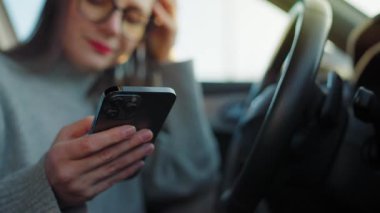 Arabada beklerken akıllı telefon kullanan mutlu güzel bir kadının portresi. Yavaş çekim