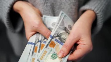 Amerikan Doları 'nı sayan bir kadın, yakın plan. Yatırım, başarı, finansal beklentiler veya kariyer ilerlemesi kavramı.