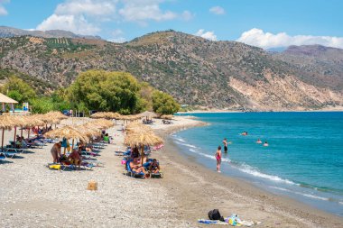 PALEOCHORA, CRETE, GREECE - 22 Temmuz 2021: Turistler Chalikia 'nın çakıl taşı plajında dinleniyor