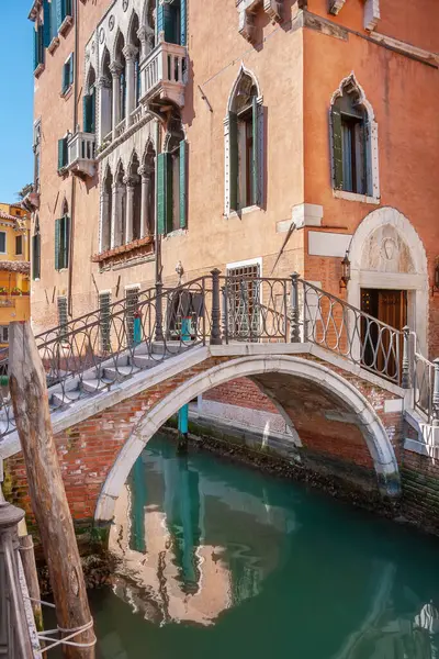 小さな橋がヴェネツィアの狭い運河を横断している イタリア ロイヤリティフリーのストック画像
