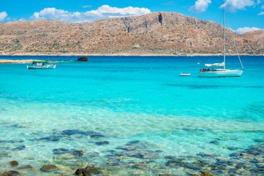 Imeri Gramvousa adasının lagününün turkuaz sularındaki tekneler. Girit, Yunanistan