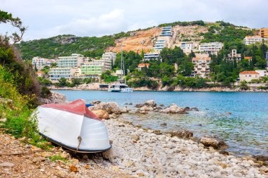 Beyaz tekne Lapad körfezinin kayalık kıyılarında dinleniyor. Dubrovnik, Hırvatistan