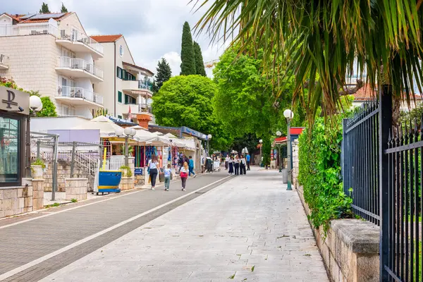 Lapad bölgesi, Dubrovnik, Hırvatistan - 26 Nisan 2025: Gezinti alanı boyunca gezinen turistler, geçmişteki dükkanlar ve kafeler
