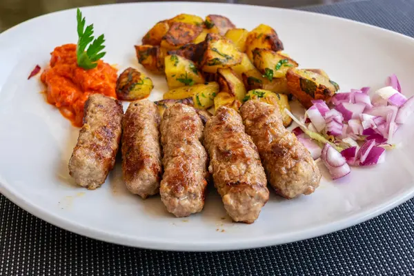 Geleneksel cevapcici (sosis) kızarmış patates ve taze soğanlı. Hırvatistan