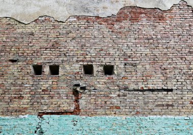 Film projektörleri için pencereleri olan terk edilmiş bir sinemanın eski tuğla duvarı.