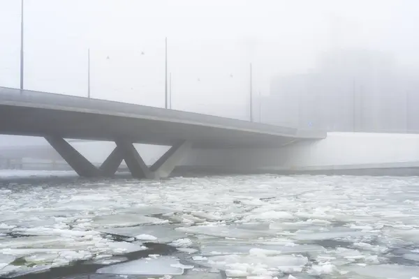 concrete bridge in heavy fog in early spring during ice drift