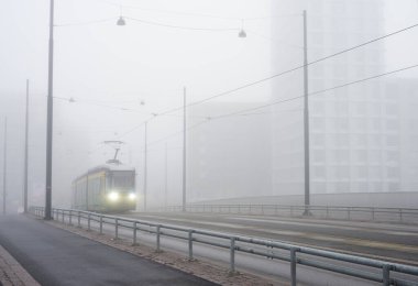 Şehir tramvayı sabahın erken saatlerinde yoğun siste şehirden geçiyor. 