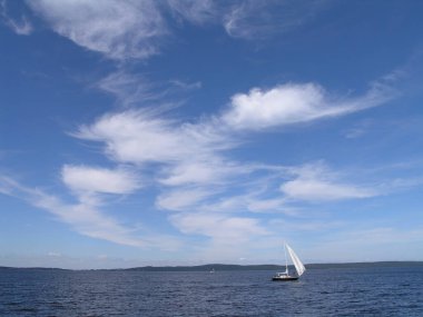 sailing boat on Lake Onega in summer, blue sky with clouds 