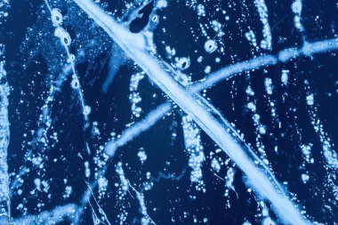 Donmuş bir nehirde buz. Karda çatlaklar olan mavi buzun arka plan dokusu. İHA üst görünümü.