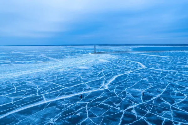 stock image aerial view of a lonely lighthouse in the frozen sea. Frozen blue ice in cracks, drone view