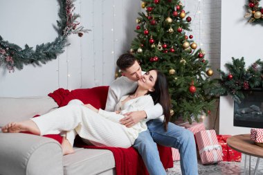 Köknar yakınında duruyor. Genç romantik çift yeni yılı içeride kutluyor..