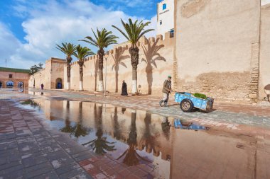 ESSAOUIRA, MOROCCO. 13 th February, 2017: Ancient walls of the medina, merchants hurrying on business, after the rain