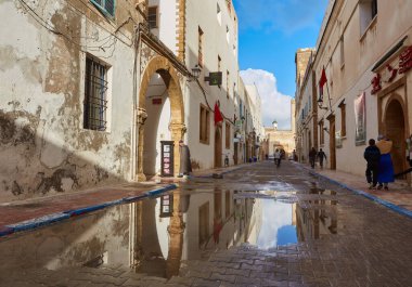 ESSAOUIRA, MOROCCO. 13 th February, 2017: Ancient walls of the medina, merchants hurrying on business, after the rain