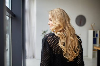 Portrait of beautiful young blonde girl with makeup in black fashion clothes