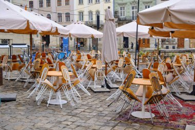 Yağmurdan sonra sabah vakti kapalı kafe veya restoranda masaya yaslanan tahta sandalyeler.