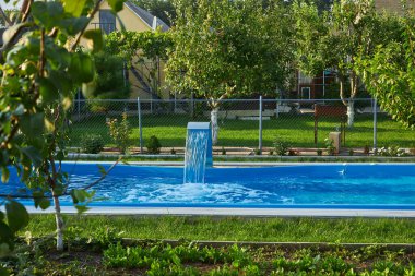 Kristal berrak yüzme havuzu, şelale, yemyeşil, seyahat, turizm, kırsal, gevşeme, zenginlik ve yaşam tarzı fikirleri ile muhteşem bir yaz ayarı