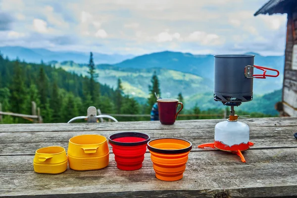 stock image Morning coffee with a view. Coffee pot and mugs full of hot drink on the gas burner high in the mountains. Outdoor paradise and wanderlust concept