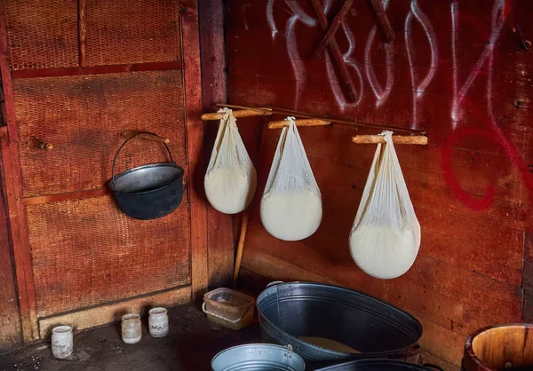 Making organic sheep cheese in wooden mountain Carpathian cheese factory with a boiling smoked cauldron with milk on open fire, Western Ukraine, Europe