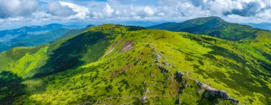 Fotoğraf, bir dağ sırtındaki haçta bir dronla çekildi. Karpatlar 'daki sıradağların yaz fotoğrafı.