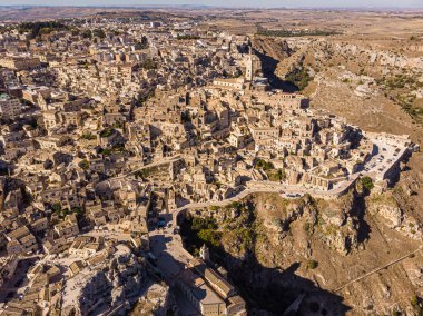 Ortaçağ şehri Matera Sassi di Matera 'nın güneşin doğuşunda güzel altın bir sabah ışığında havadan görünüşü. İtalya 'nın güneyindeki Basilicata' da Sassi di Matera 'nın kuşların bakış açısı ve bir Unesco dünya mirası..