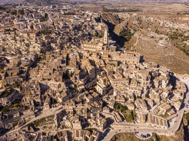 Yukarıdan bakıldığında, Matera 'nın güzel bir gündoğumu sırasında gökyüzünün çarpıcı görüntüsü. Matera, İtalya 'nın güneyindeki Basilicata bölgesinde kayalık bir çıkıntı üzerine kurulmuş bir şehirdir..