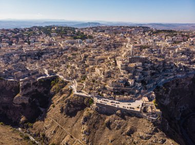 Yukarıdan bakıldığında, Matera 'nın güzel bir gündoğumu sırasında gökyüzünün çarpıcı görüntüsü. Matera, İtalya 'nın güneyindeki Basilicata bölgesinde kayalık bir çıkıntı üzerine kurulmuş bir şehirdir..