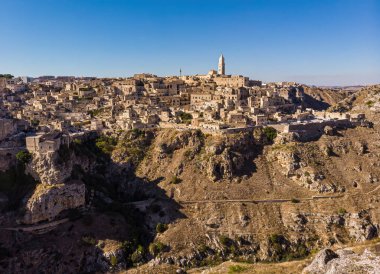 Ortaçağ şehri Matera Sassi di Matera 'nın güneşin doğuşunda güzel altın bir sabah ışığında havadan görünüşü. İtalya 'nın güneyindeki Basilicata' da Sassi di Matera 'nın kuşların bakış açısı ve bir Unesco dünya mirası..