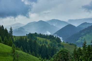 Dağlardaki yaz manzarası ve bulutlu koyu mavi gökyüzü.