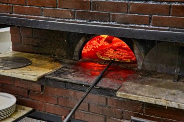 Baked tasty margherita pizza in Traditional wood oven in Naples restaurant, Italy. Original neapolitan pizza. Red hot coal. clipart