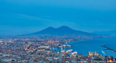 Napoli, İtalya. Napoli Körfezi 'nin üzerinde gün batımının güzel ışıkları ön planda marina ve arka planda Vezüv Dağı var..