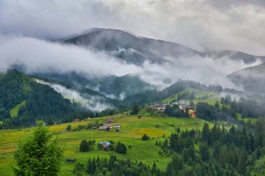 Dağlardaki yaz manzarası ve bulutlu koyu mavi gökyüzü.