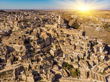 Ortaçağ şehri Matera Sassi di Matera 'nın güneşin doğuşunda güzel altın bir sabah ışığında havadan görünüşü. İtalya 'nın güneyindeki Basilicata' da Sassi di Matera 'nın kuşların bakış açısı ve bir Unesco dünya mirası..