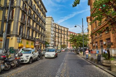 Napoli, İtalya - 24 Ekim 2019: Sokaktaki arabalar ve Napoli setin yanındaki antik kırmızı bina. Campania, İtalya.