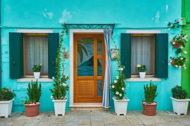 Blue facade of the house with door and windows. Colorful architecture in Burano, Italy.