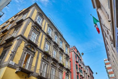 Napoli, İtalya - 25 Ekim 2019 - Şehir sakinleri tarihi Centro Storico şehir merkezinin dar çamaşırhaneli caddesinde park halindeki araçlar arasında yürürler..