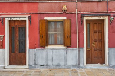 Evin kırmızı cephesindeki kapı ve pencereler. Burano Adası, Venedik, İtalya 'da renkli mimari.