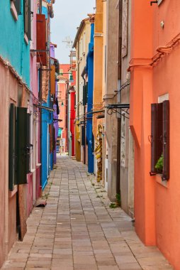 Burano adası, renkli binalar arasında dar kaldırım taşı caddesi çok renkli duvarlar, mavi gökyüzü güneşli yaz günü, Venedik Eyaleti, Veneto Bölgesi, Kuzey İtalya. Burano kartpostalı