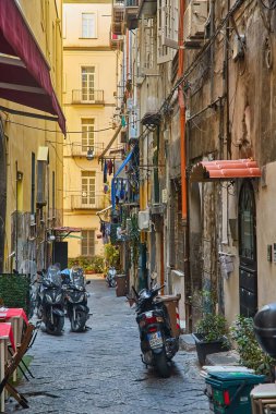 Napoli, İtalya - 25 Ekim 2019: İtalya 'nın Napoli, İtalya' nın tarihi merkezinde İtalyan bayrakları ve bir sürü motosiklet ve scooterlı klasik romantik küçük cadde